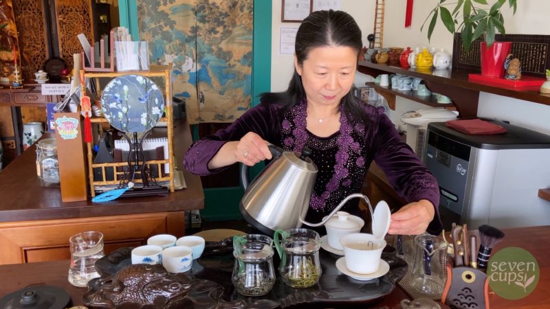 Zhuping in the teahouse pouring water into a gaiwan.
