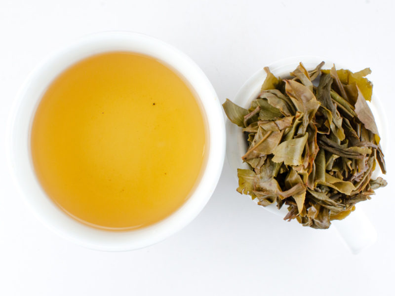 Cupped infusion of Xiaohuzhai sheng puer tea and strained leaves.
