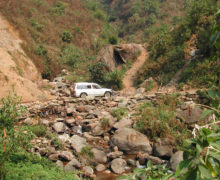 A vehicle traversing the rough mountain road.
