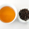 Cupped infusion of Zijuan Hong (Yunnan Purple Leaf Black) black tea and strained leaves.