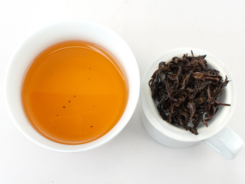 Cupped infusion of Zijuan Hong (Yunnan Purple Leaf Black) black tea and strained leaves.