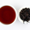Cupped infusion of Cha Tao puer tea and strained leaves.