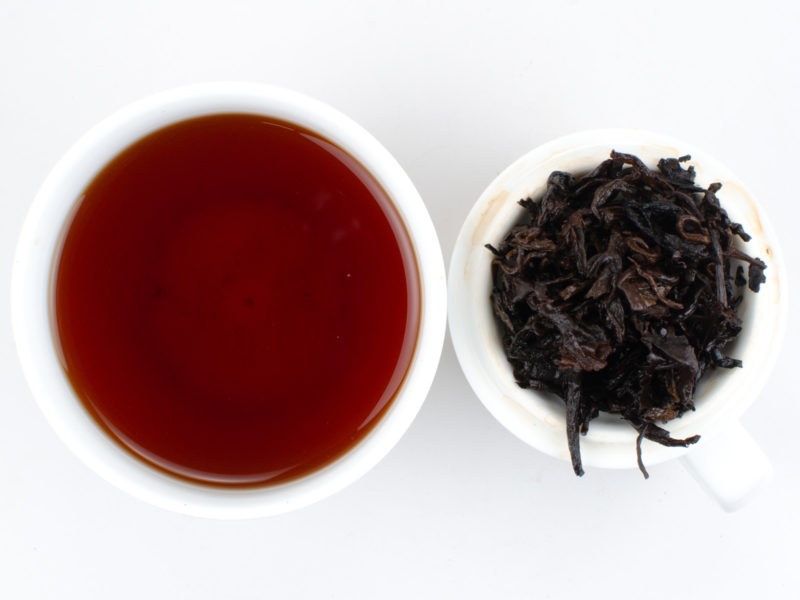 Cupped infusion of Cha Tao puer tea and strained leaves.