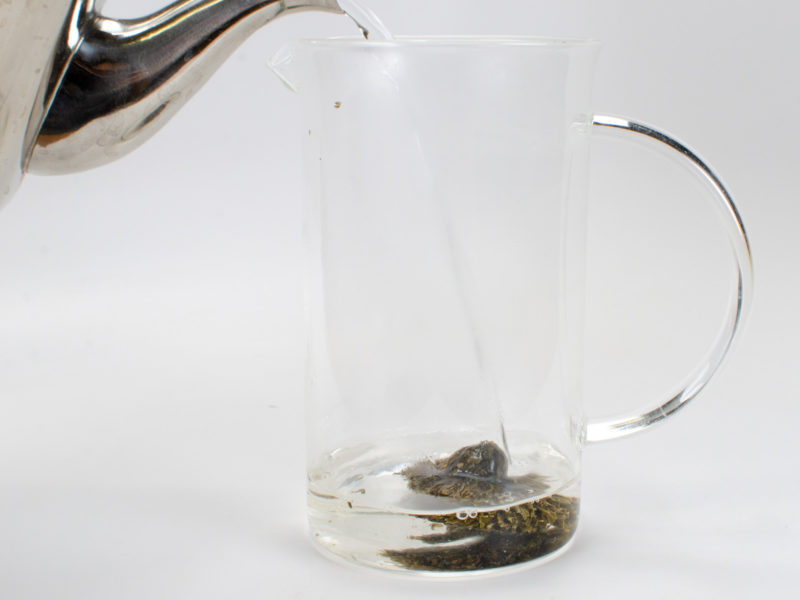 Pouring hot water over Chrysanthemum Green Blooming Tea