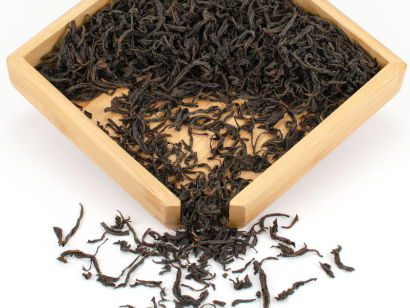 Chi Gan (Sweet Vermilion) black tea dry leaves in a wooden display box.