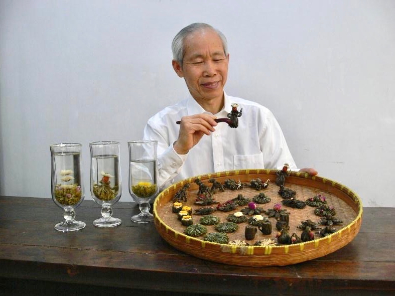 Wang Fangsheng with several of the blooming display teas he invented and designed.
