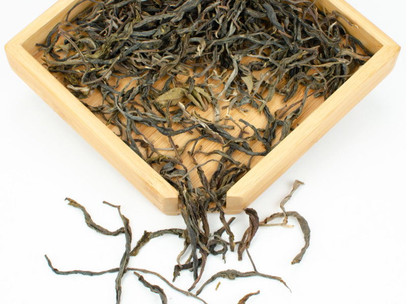 Yiwushan (Yiwu Mountain) 2020 sheng puer tea dry leaves in a wooden display box.