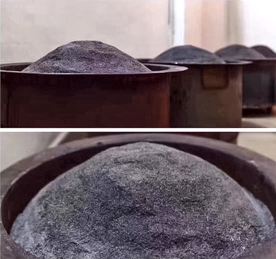 Dark charcoal ash mounded high in several large round metal stoves for roasting Dan Cong Wulong tea.