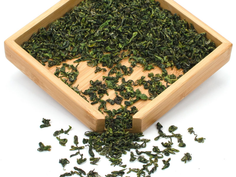 Late Spring Mogan green tea dry leaves in a wooden display box.