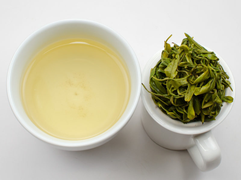 Cupped infusion of Late Spring Mogan green tea and strained leaves.