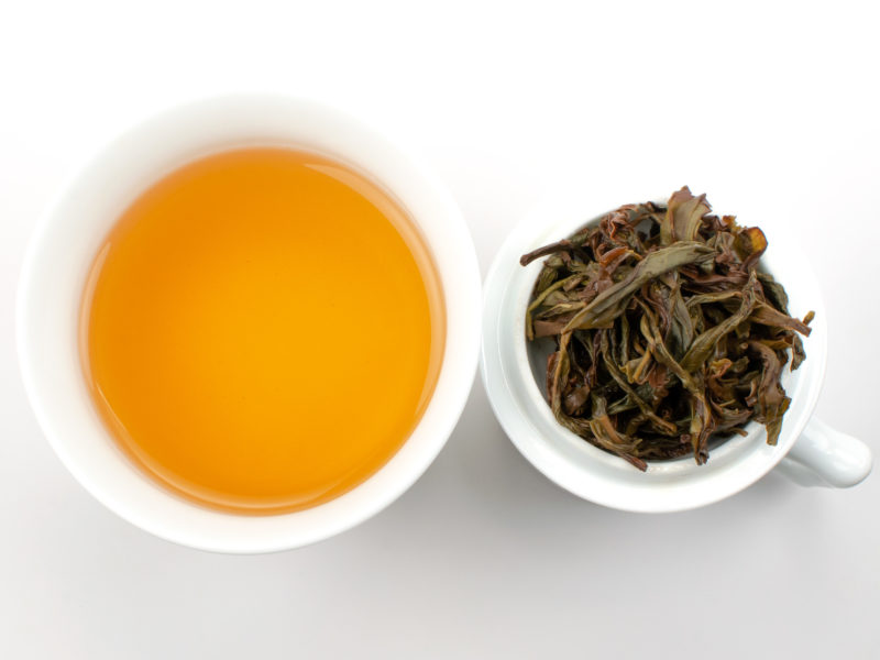 Cupped infusion of Jianghua Xiang (Ginger Flower) Dan Cong wulong tea and strained leaves.