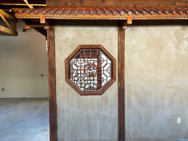 The warm earthen walls and traditional ba gua window in the new teahouse.