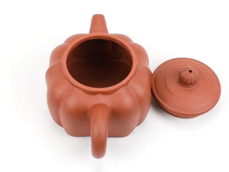 Red Ribbed Yixing Teapot with lid open to show strainer inside behind spout.