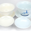 The crisp pure white color of the Jingdezhen Plum Blossom Porcelain Gaiwan next to the warm white of a White Suet Jade Gaiwan.