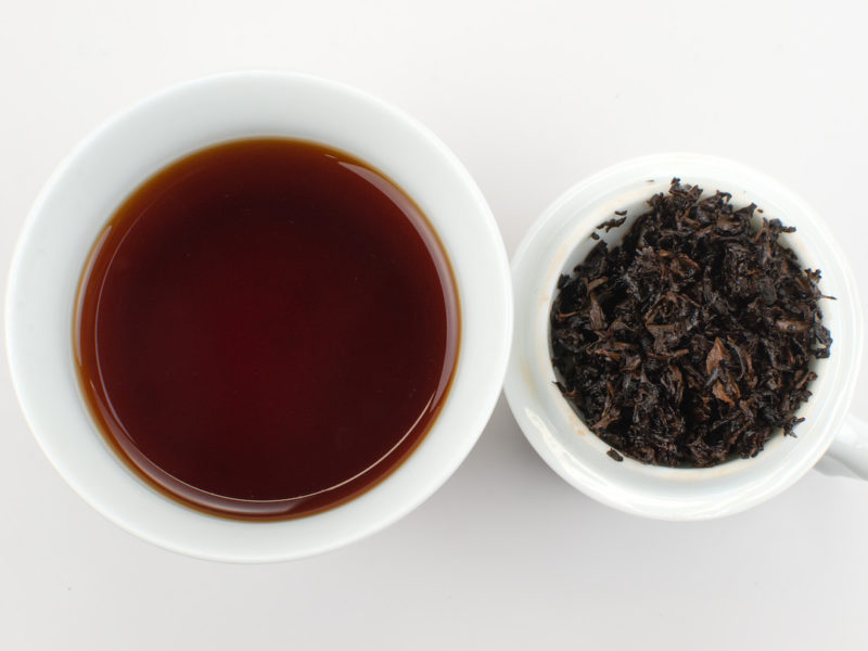 Cupped infusion of Zao Xiang (Date Fragrance) shu puer tuocha and strained leaves.