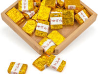 Zao Xiang (Date Fragrance) mini shu puer bricks individually wrapped in golden foil, in a wooden display box.