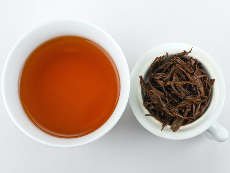 Cupped infusion of Zhongguo Hong (China Red) black tea and strained leaves.