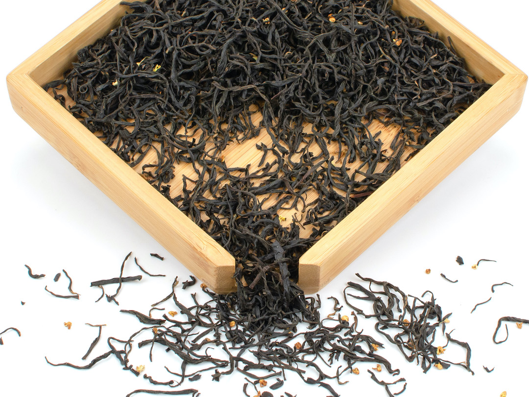 Gui Hua Qimen (Osmanthus Keemun) black tea dry leaves in a wooden display box.