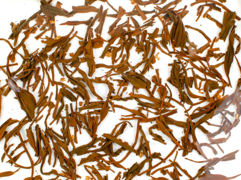 Gui Hua Qimen (Osmanthus Keemun) tea leaves floating in clear water.