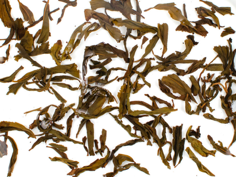 Qi Dan (Rare Crimson) tea leaves floating in clear water.