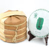 A tong of stacked Hei Tiao Zi (Black Stripe) sheng puer cakes wrapped in bamboo.