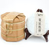 A tong of stacked Gongting (Palace Puer) shu puer cakes wrapped in bamboo.
