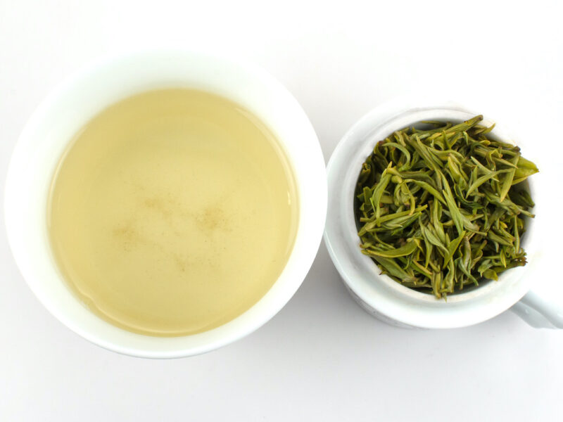 Cupped infusion of Lao Cha Yuan Ganlu (Old Garden Sweet Dew) green tea and strained leaves.