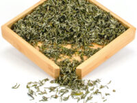 Lao Cha Yuan Ganlu (Old Garden Sweet Dew) green tea dry leaves in a wooden display box.