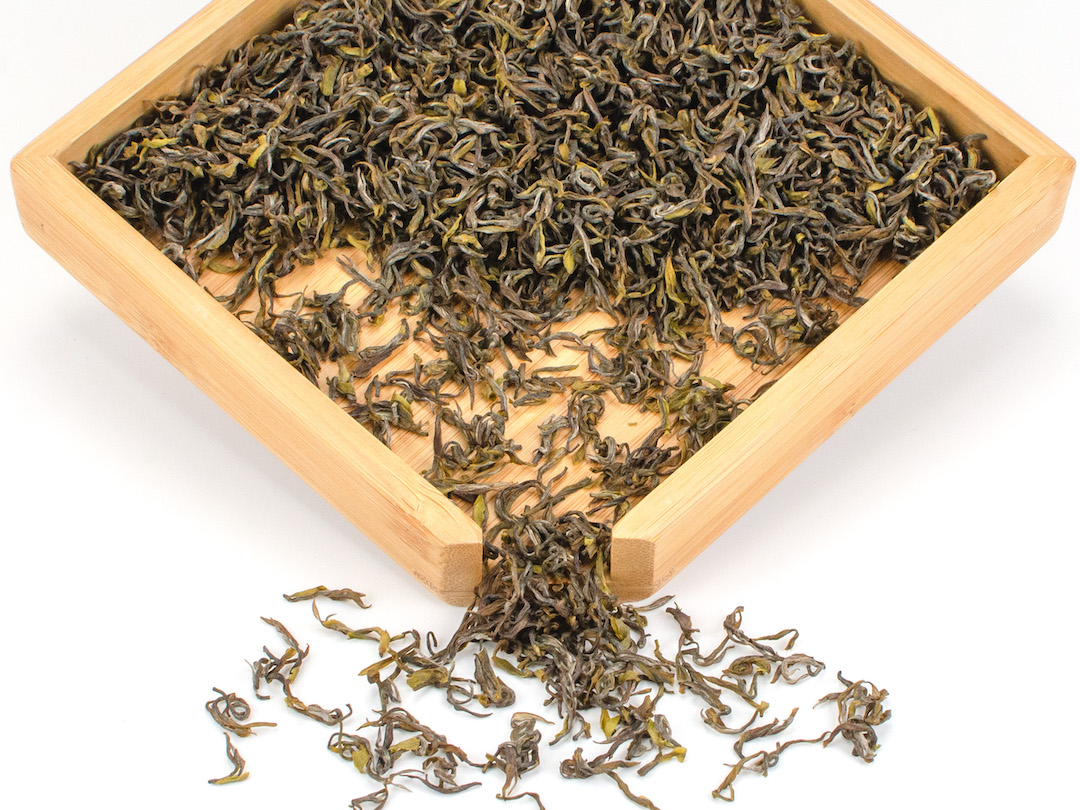 Early Spring Mogan Yellow tea dry leaves in a wooden display box.