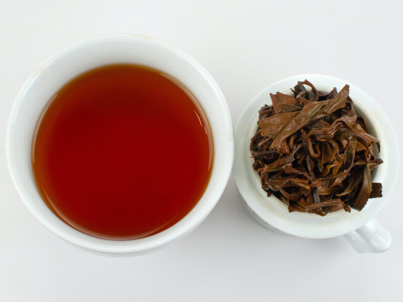 Cupped infusion of Jingmai Sun-Dried black tea and strained leaves.