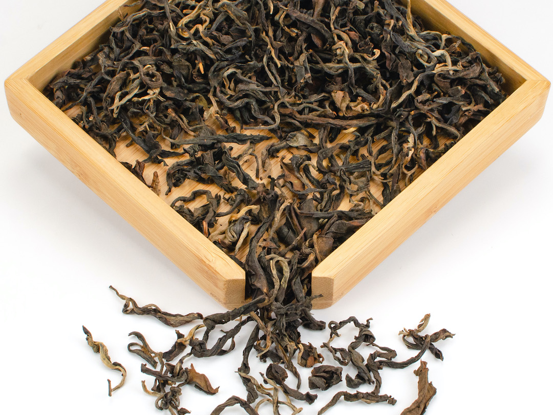 Jingmai Sun-Dried black tea dry leaves in a wooden display box.