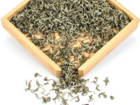 Zhi Xiang Ganlu (Gardenia Sweet Dew) scented green tea dry leaves in a wooden display box.