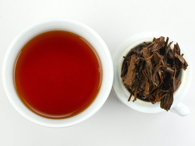Cupped infusion of Naka Sun-Dried black tea and strained leaves.
