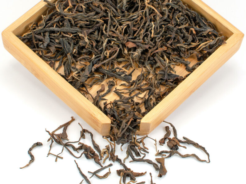 Naka Sun-Dried black tea leaves displayed on a bamboo tray.