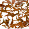 Naka Sun-Dried black tea leaves floating in clear water.