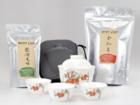 The two teas and travel tea set included in The Essentials Kit, with one easy gaiwan, three cups, and their carrying case.