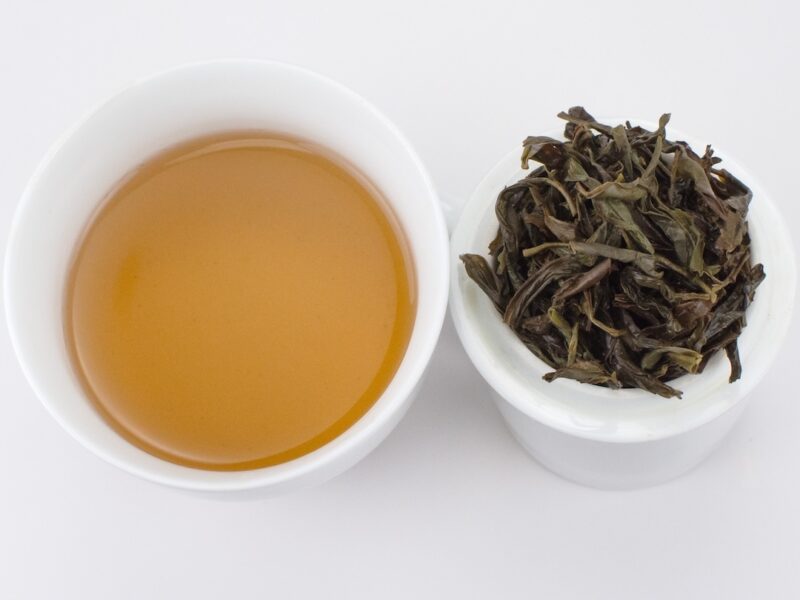 Cupped infusion of Ao Fu Hou (Beyond the Road) Dan Cong wulong tea and strained leaves.