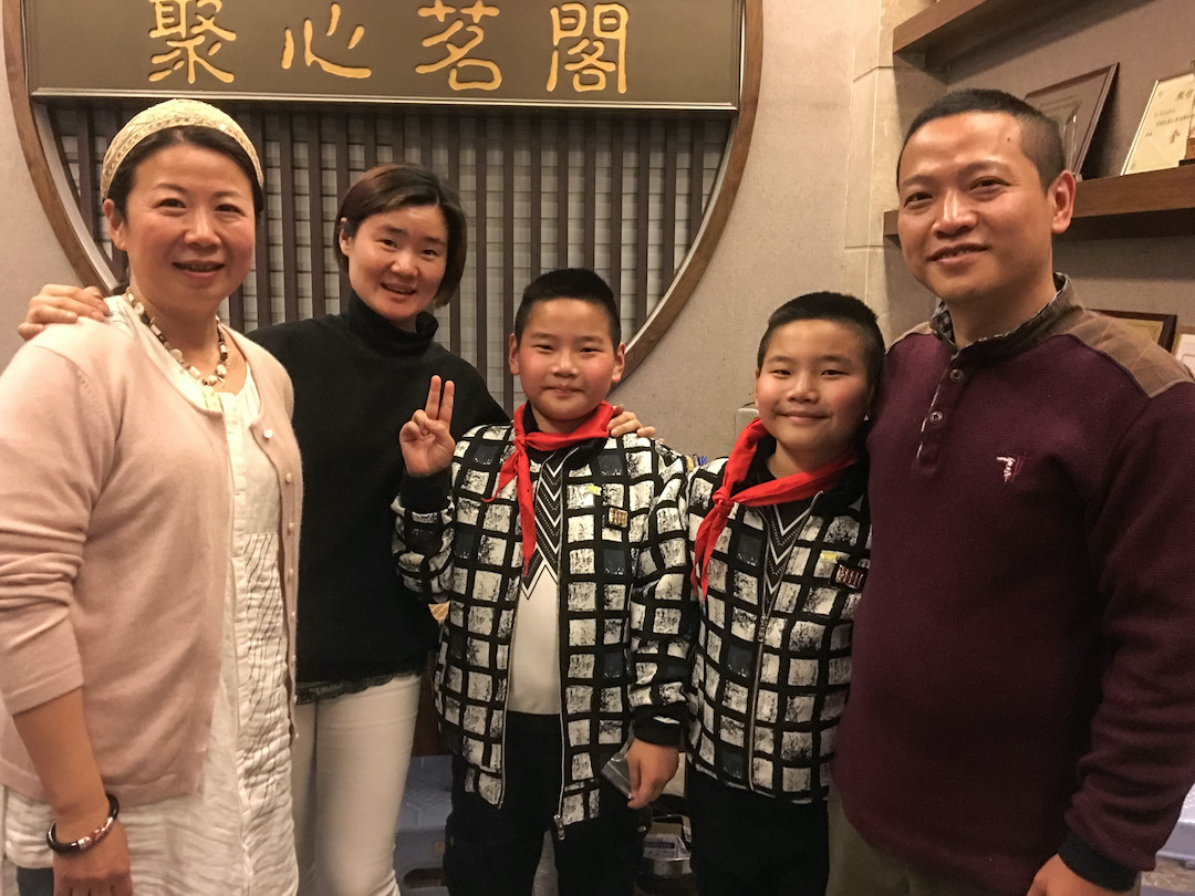 A man, two women, and two young twin boys all smiling for the camera.