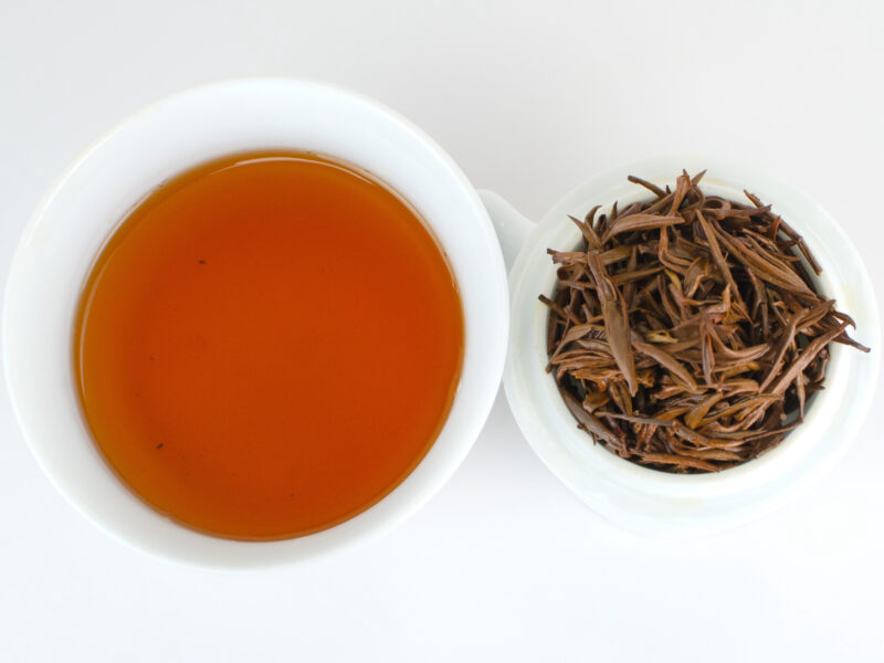 Cupped infusion of Jin Jun Mei (Champion Steed) Tongmu black tea and strained leaves.