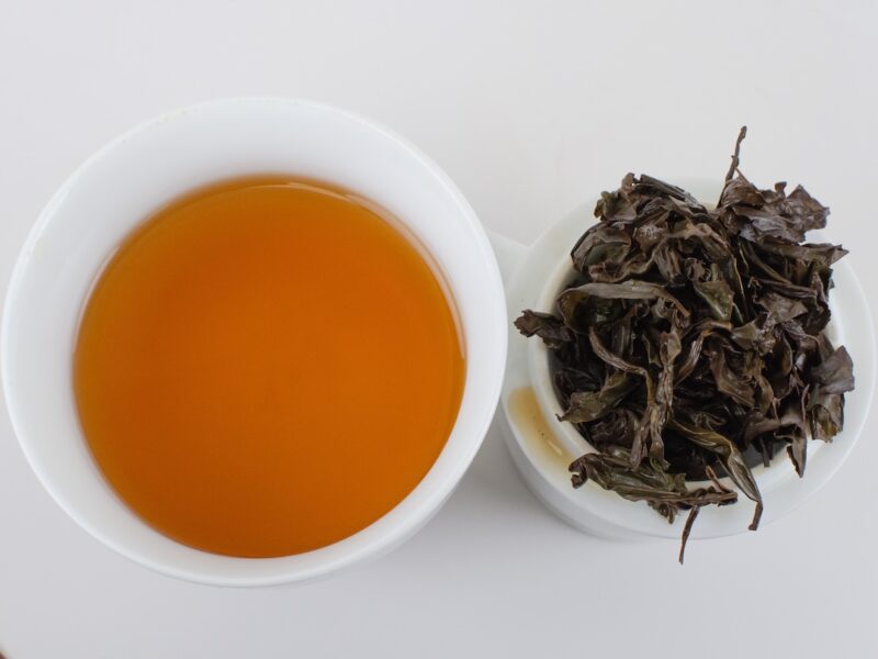 Cupped infusion of Tongmu Rougui (Tongmu Cassia Bark) rock wulong tea and strained leaves.