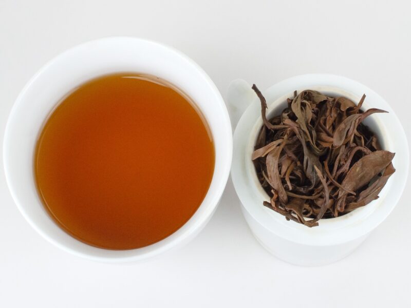 Cupped infusion of Baotang Pond Sun-Dried black tea and strained leaves.