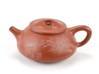 Carved plum branch detail on Red Stone Scoop Zhu Ni Yixing Teapot