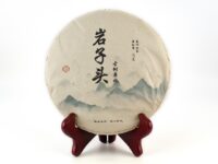 Yanzi Tou (Rock Head) Sheng Puer Cake enclosed in its wrapper.