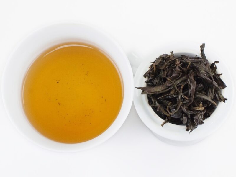 Infusion of Bai Rui Xiang (Hundred Blooms) rock wulong tea and strained leaves.