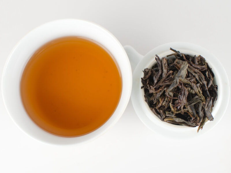 Cupped infusion of Mi Lan Xiang (Honey Orchid) Dan Cong wulong tea and strained leaves.