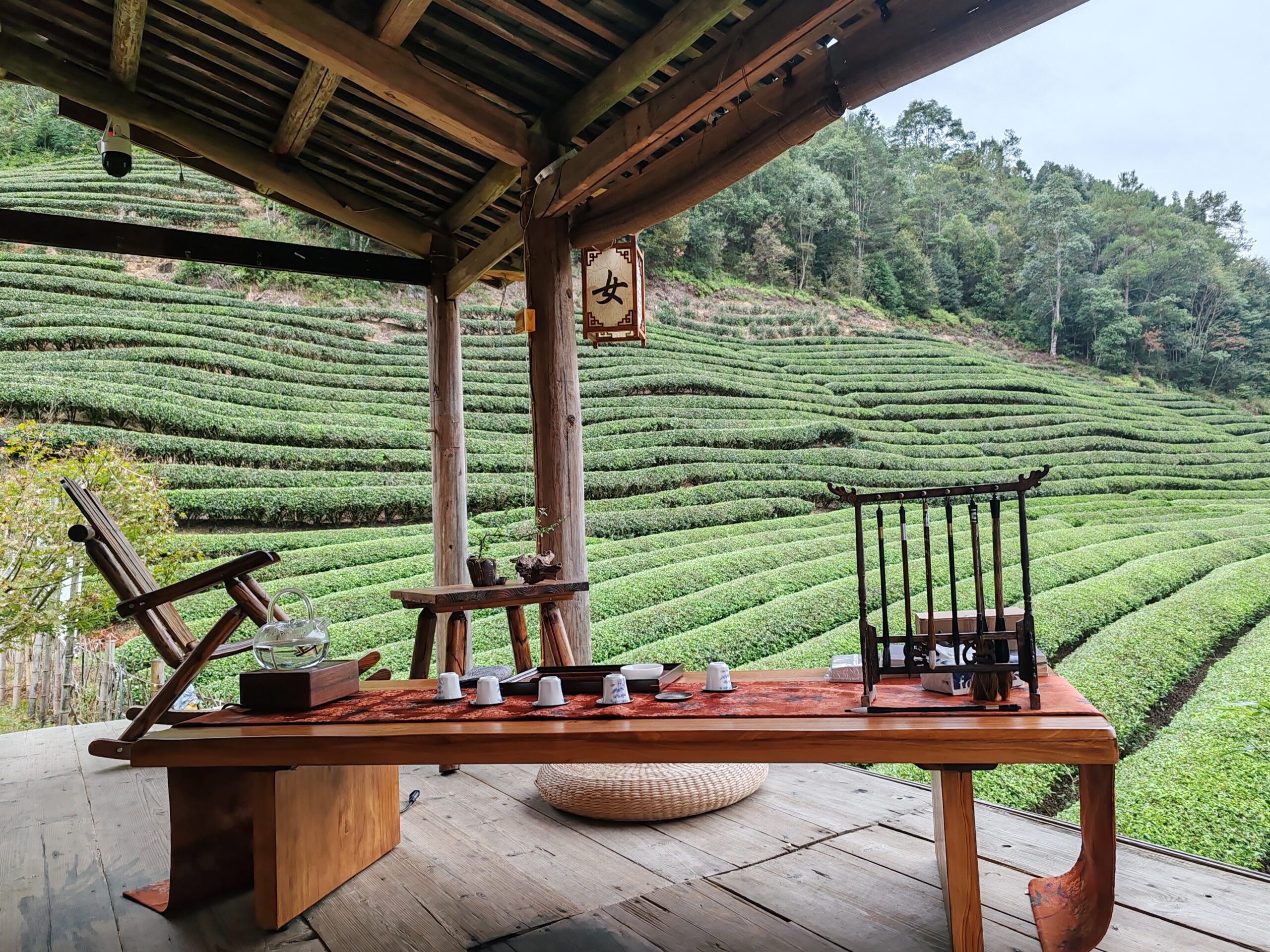 a tea table on a porch among terraces of tea bushes in Wuyishan, Fujian. 