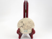 Youle Gaoshu (Youle Tall Tree) sheng puer cake in paper wrapper.