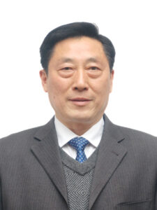 a man in a grey suit. He is the chairman of the Shennong Tea Industry company.